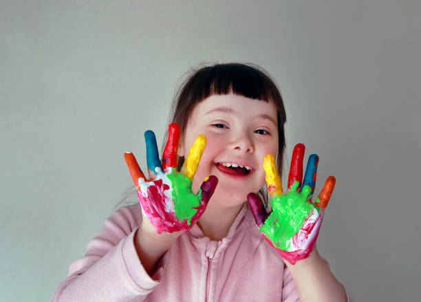 söt liten flicka med målade händer. isolerad på grå bakgrund. - downs syndrome work bildbanksfoton och bilder