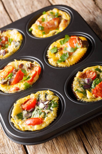 istock Breakfast egg muffins with bacon, tomatoes, spinach and mushrooms close-up in a baking dish. vertical 1180053566