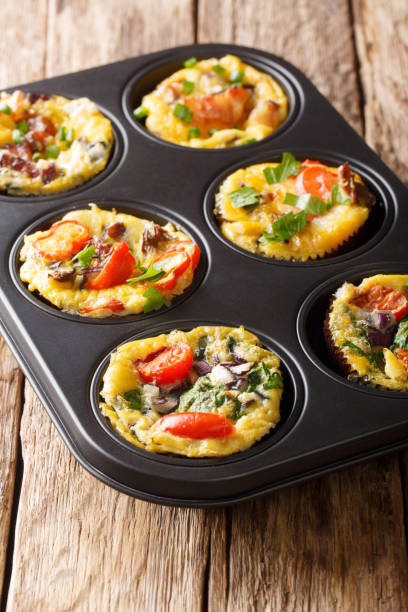 istock egg muffins omelet with bacon, tomatoes, spinach and mushrooms close-up in a baking dish. vertical 1180053626