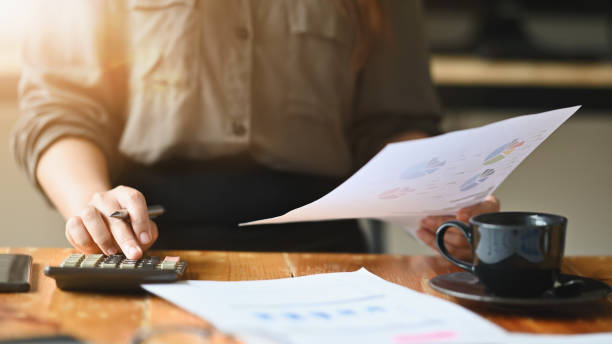 istock Cropped shot accounting calculate and reading financial data paper. 1180053709