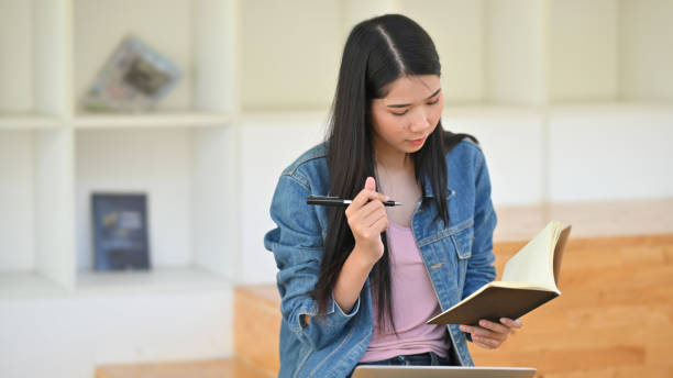 istock Young woman thinking wait writing on notebook paper. 1180053841