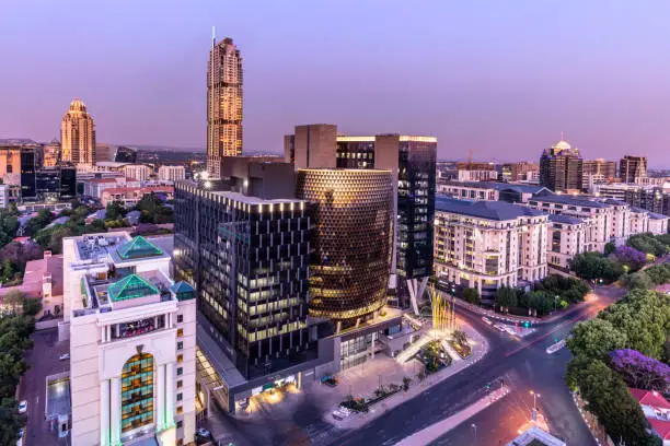 Sandton City panorama at dusk with the Leonardo building, Michelangelo apartments and sandton city office towers.
Sandton has become home to most of the major financial, consulting and banking firms in South Africa.  Sandton houses approximately 300000 residents and 10 000 businesses, including investment banks, top businesses, financial consultants, the Johannesburg stock exchange and one of the biggest convention centres on the African continent, the Sandton Convention Centre.