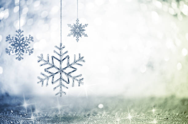 Three Decorative Hanging Snowflakes against Glittering Defocused Background