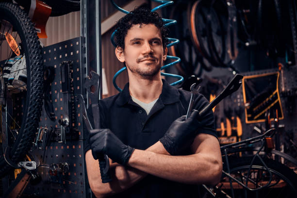 istock Young attractive mechanic is posing next to bicycle at his own workshop 1180055786