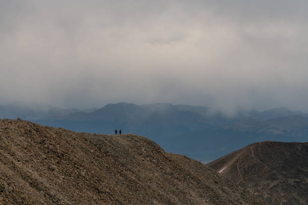 Two Hikers on Mount Sherman - Colorado On a cloudy night, two hikers descend from one of Colorado's fourteeners. tenmile range stock pictures, royalty-free photos & images