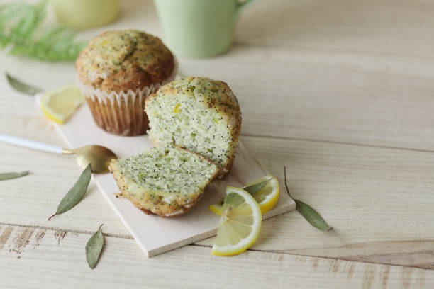 Lemon poppy seed mini muffins Lemon poppy seed muffins on wooden tray with yellow and green cups, slices of lemon and eucalyptus leaves poppy seed stock pictures, royalty-free photos & images