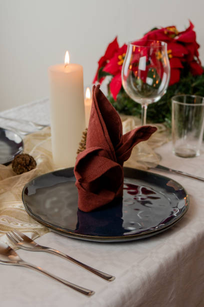 istock Christmas table setting for two, with four candels, blue plates and a red table napkin. 1180063823