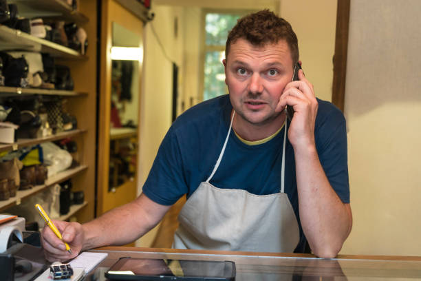 istock Shoemaker in shoe repair shop 1180064146