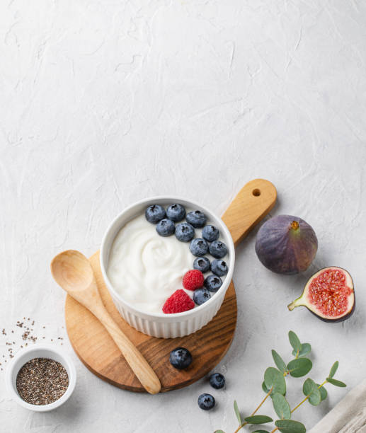 istock White fermented yogurt with blueberry, figs, chia seeds and raspberry in bowl on light gray table 1180065595