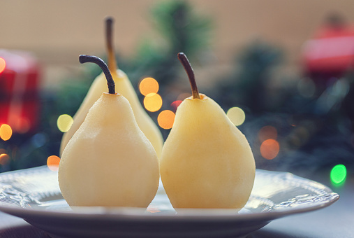 Preparing poached pears glazed with dark chocolate for the holidays at home