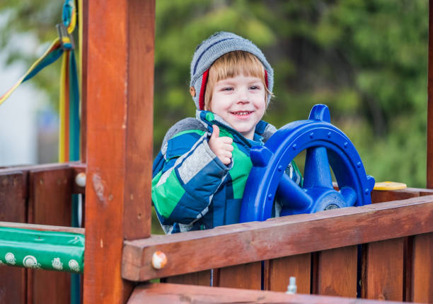 Small cute boy playing alone at playground outdoors