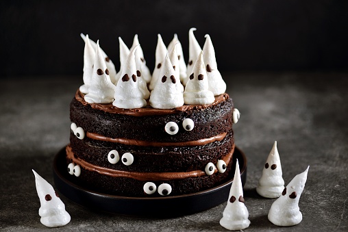 Homemade Chocolate Cake with Chocolate cream and Meringue Ghost and Eyes for Halloween Party.