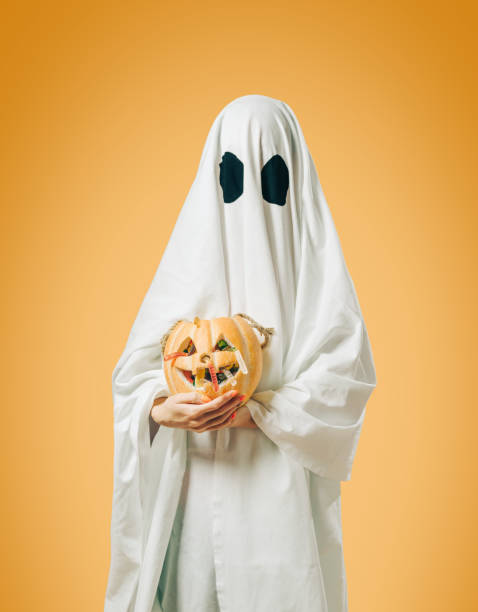 istock White ghost with Halloween trick-or-treat pumpkin basket. 1180069736