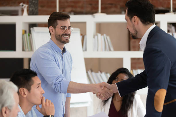 istock Smiling colleagues handshake greeting at office meeting 1180069913