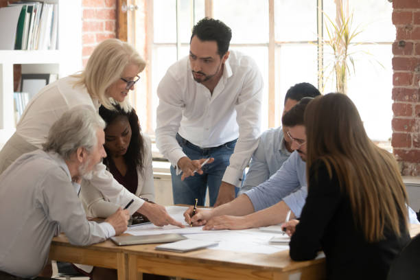 istock Diverse employees brainstorm discussing paperwork at briefing 1180069923
