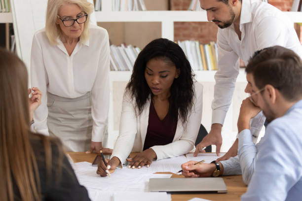 istock Concentrated colleagues brainstorm discussing paperwork at briefing 1180069931