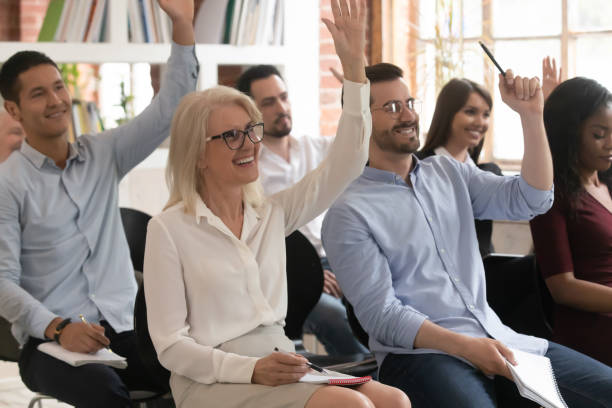 istock Motivated diverse employees raise hand participating in training 1180069944