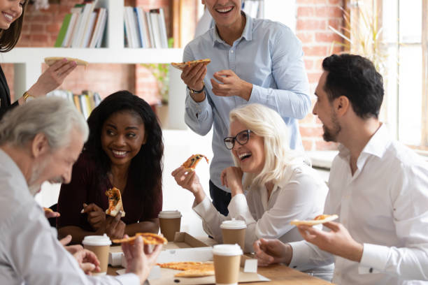 istock Happy diverse colleagues have lunch eating pizza together 1180069946