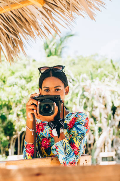 istock Young Black woman with retro digital camera 1180070377