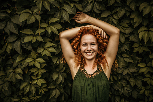 Serie of photos of female model in green dress posing on meadow. Outdoor portrait with natural light.