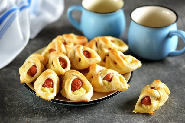istock Sausages in puff pastry with mashed potatoes on a dark background. 1180072664