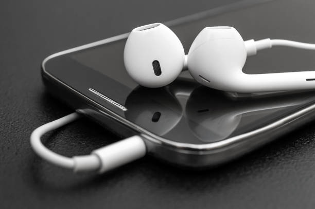 Smartphone with headphones on black. Close up. stock photo
