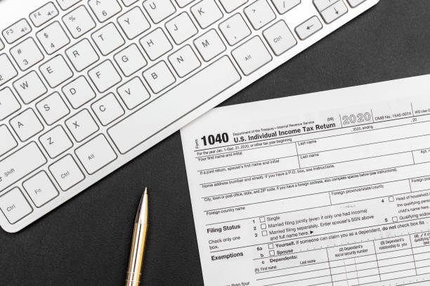 istock Tax form with computer keyboard and pen at workplace. 1180076196