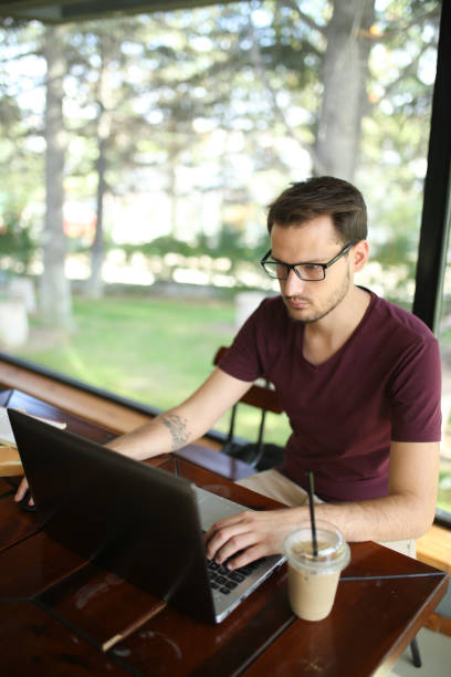 istock Student studying to become a businessman, while sitting behind his notebook at cafe. Concept of young business people 1180077466