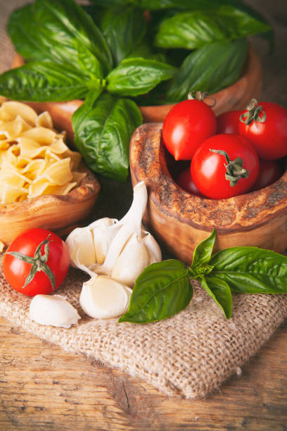 Pasta with cherry tomato, basil and garlic on rustic wooden background