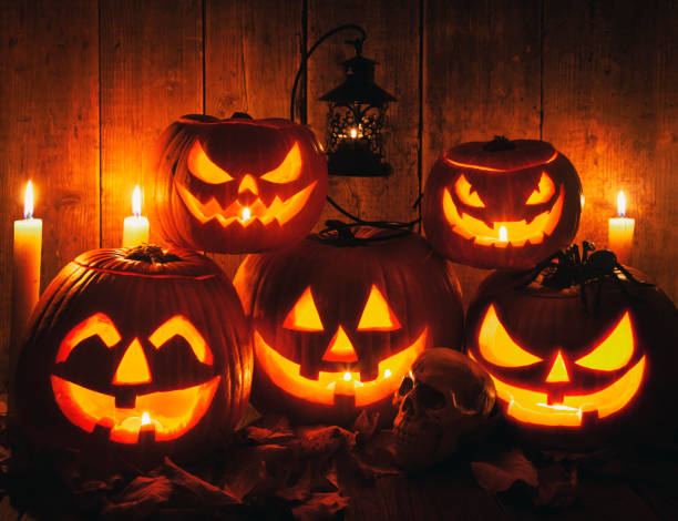 Halloween Jack-o-Lantern Pumpkins on rustic wooden background
