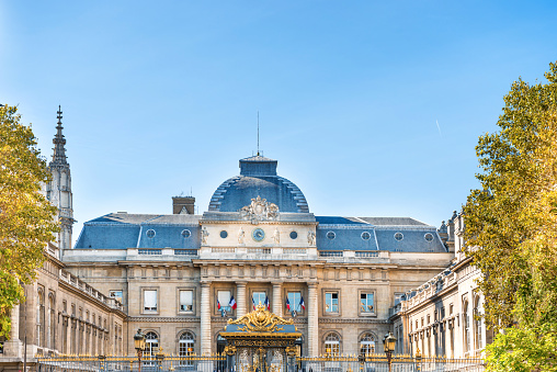 Facade view of Palais de Justice building behind fence. Paris, France