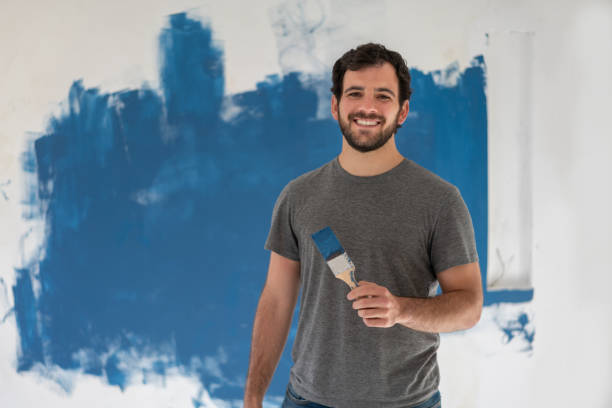 istock Happy man painting his house blue 1180087390