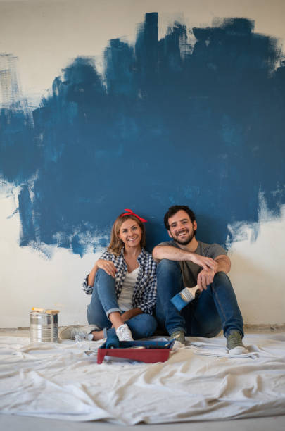 istock Couple taking a break from painting their house 1180087428