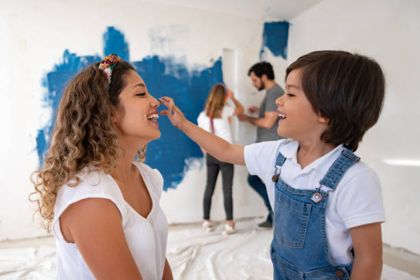 istock Mother and son having fun while painting the house 1180089660