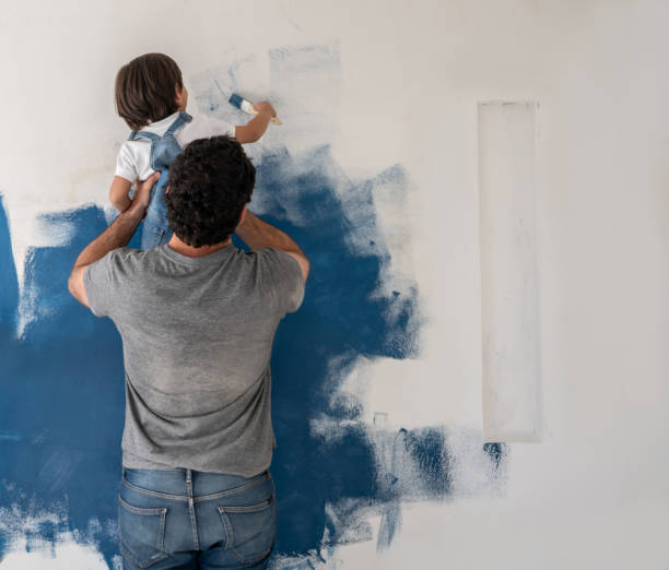 boy helping his father painting the house - home addition home improvement paint decorating imagens e fotografias de stock