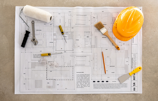 Blueprints lying on a construction site while remodeling a house - home improvement concepts