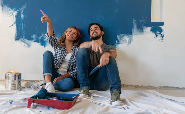 istock Couple remodeling their house and taking a break from painting 1180089726