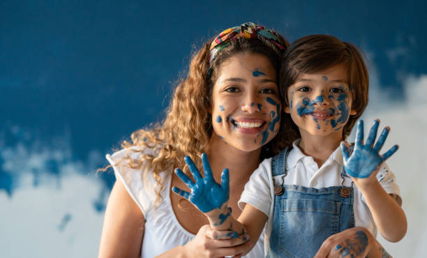 istock Happy mother and son having fun playing with paint 1180089740