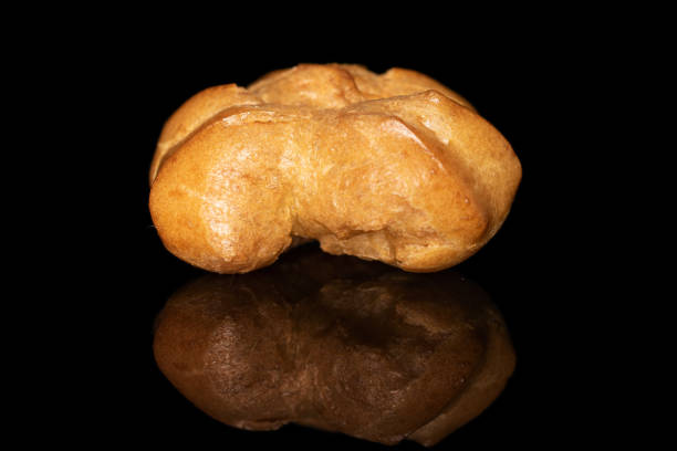 istock Golden baked profiterole isolated on black glass 1180091289