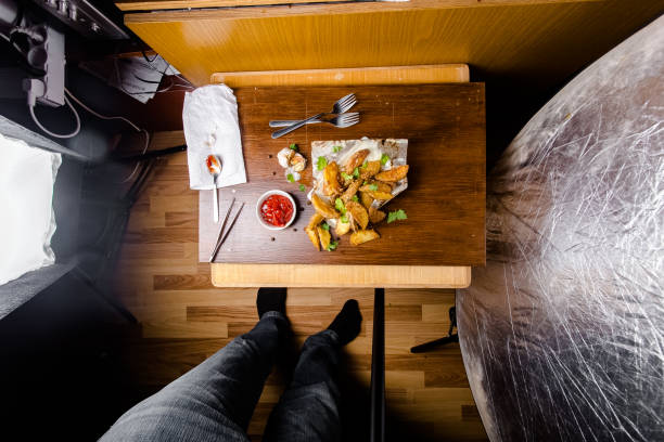new large hamburger burger with meat, bacon, sausage, lettuce, champignons, pineapple and tomatoes, sauce and cheese standing on a wooden cutting kitchen board, on the table