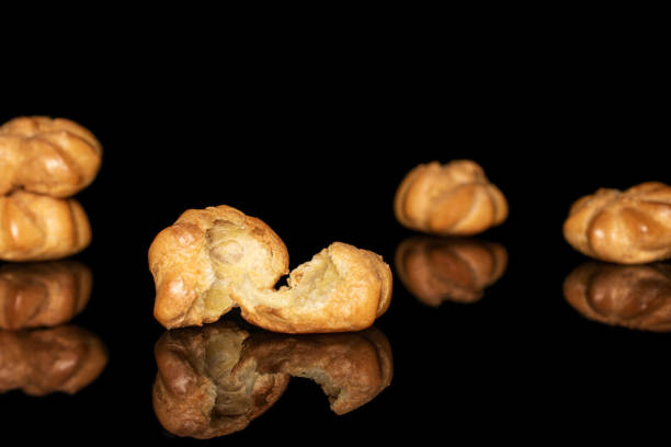 istock Golden baked profiterole isolated on black glass 1180091328