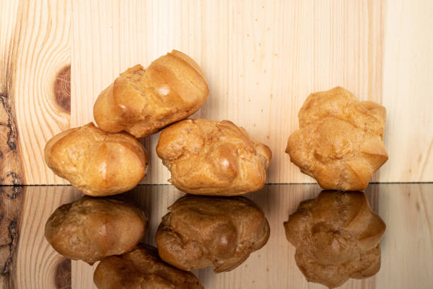 Golden baked profiterole on glass with wood
