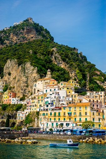 Image taken of beautiful Amalfi Coast views, featuring Italian boating with their homes built the cliffs of the town of Amalfi