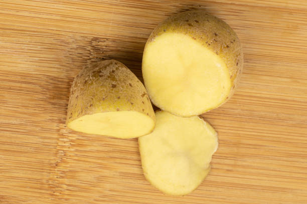 istock Raw brown potato on light wood 1180097542