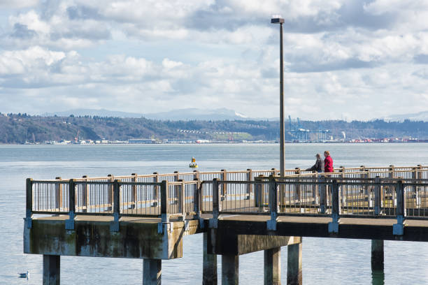 Tacoma Washington - February 20th, 2016 : Senior couple enjoying spring sunshine on the Point Defiance Park and looking over the puget sound in University Place Washington.