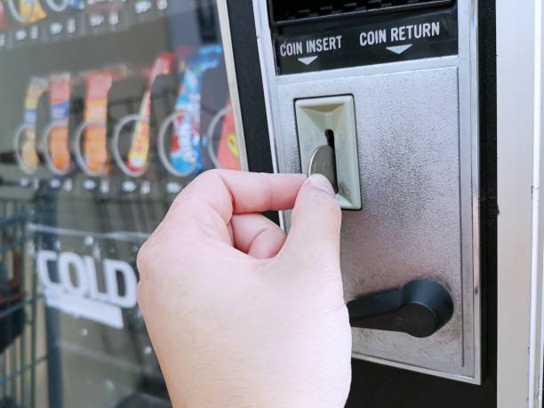 pagar con un cuarto de moneda en una máquina expendedora - vending machine fotos fotografías e imágenes de stock