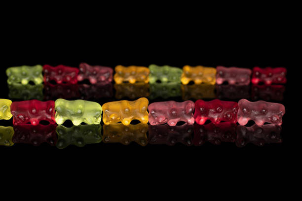 istock Colorful gummy bear isolated on black glass 1180102440