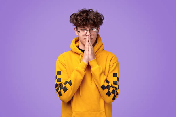 istock Contemporary teenager praying with clasped hands 1180106534