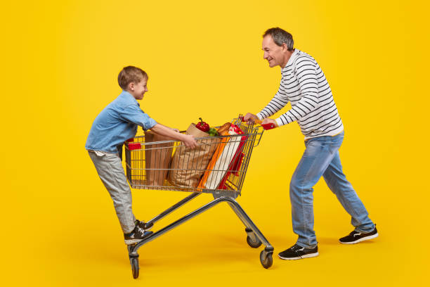 istock Father and son having fun in grocery store 1180106570