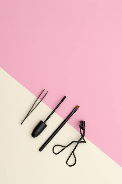 Tools for eyelashes care From above set of various accessories for eyelashes grooming placed on pink and yellow background clump eyelashes stock pictures, royalty-free photos & images